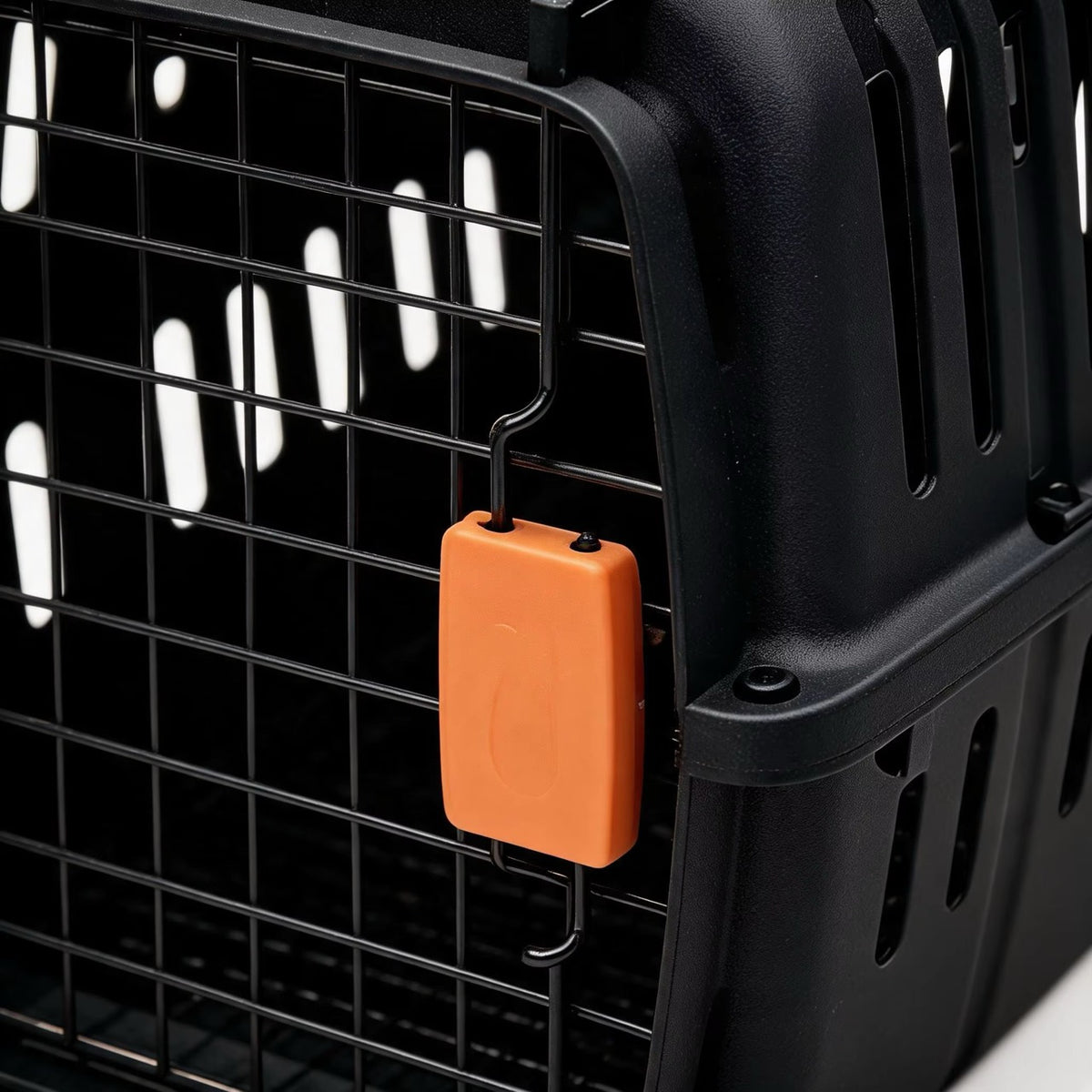 Detalj av sikkerhetslåsen på svart transportbur for katt